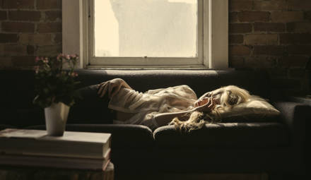 femme allongée sur un canapé à l'intérieur d'une maison
