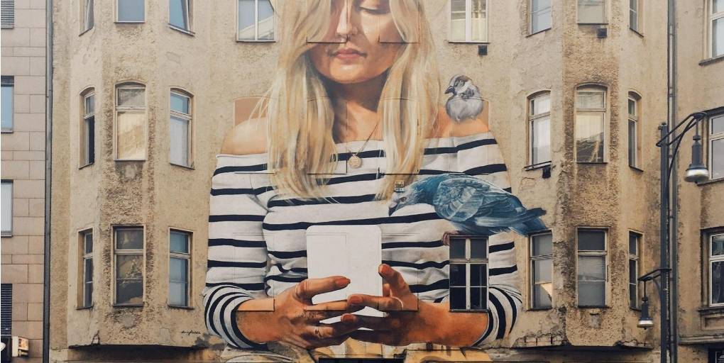 fresque murale d'une femme avec un mobile dans les mains