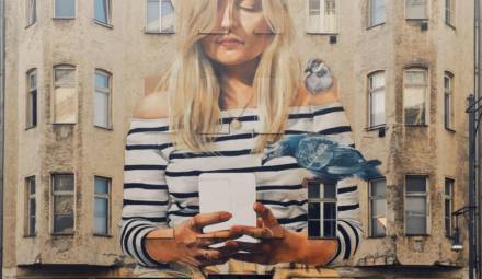 fresque murale d'une femme avec un mobile dans les mains