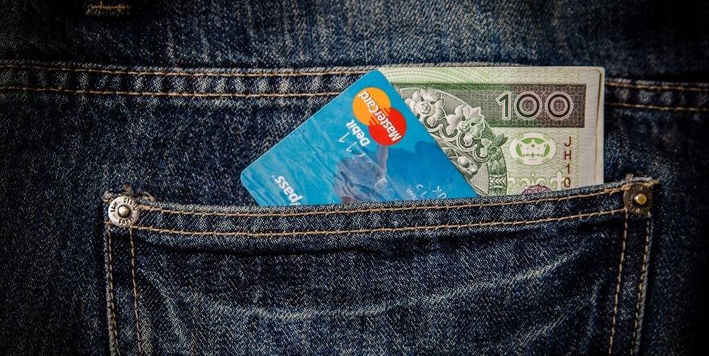 Une carte bancaire MasterCard et un billet dans une poche