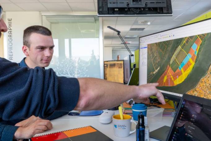 Deux personnes face à un ordinateur étudie une carte produite par imaGeau